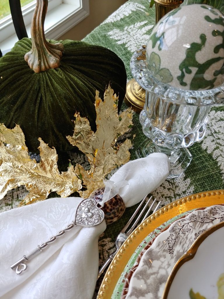 gold leaves and green pumpkin on table
