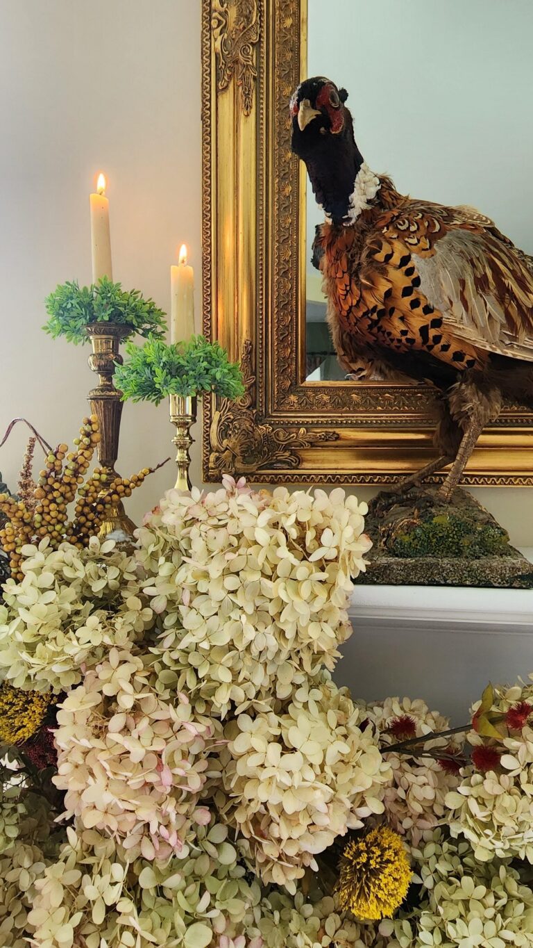floral swag on mantel with stuffed pheasant on it