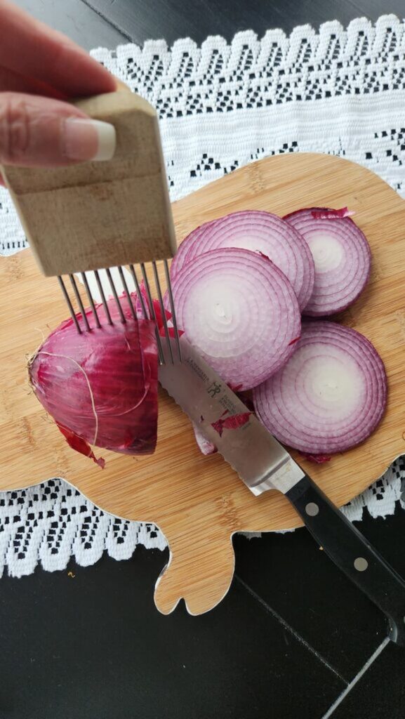 slicing red onion on cutting board