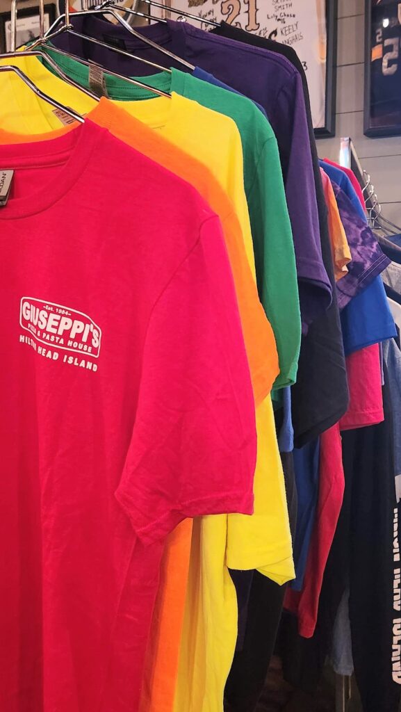 red, orange, yellow, green and purple tee shirts with giuseppi's on the them