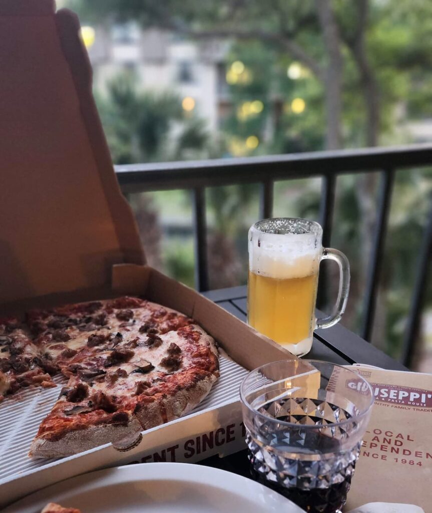 pizza and glass of beer on outdoor patio table