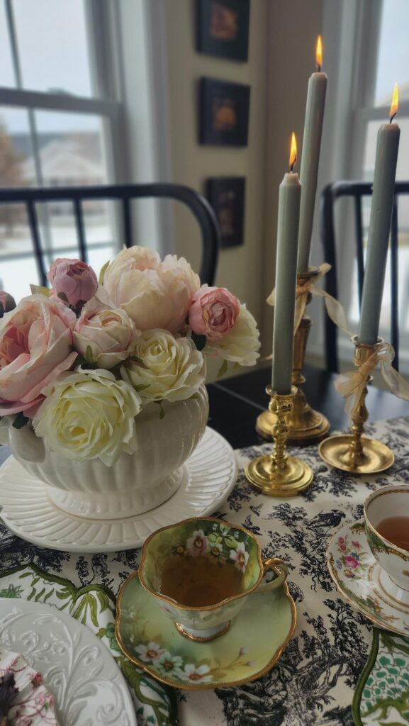 three candles on table with pink floral arrangement