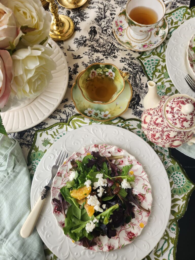 overhead view of citrus salad with vintage dishes and teacups