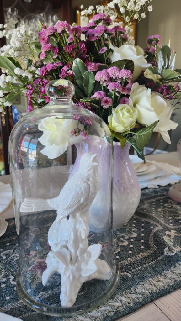 white porcelain bird under glass cloche