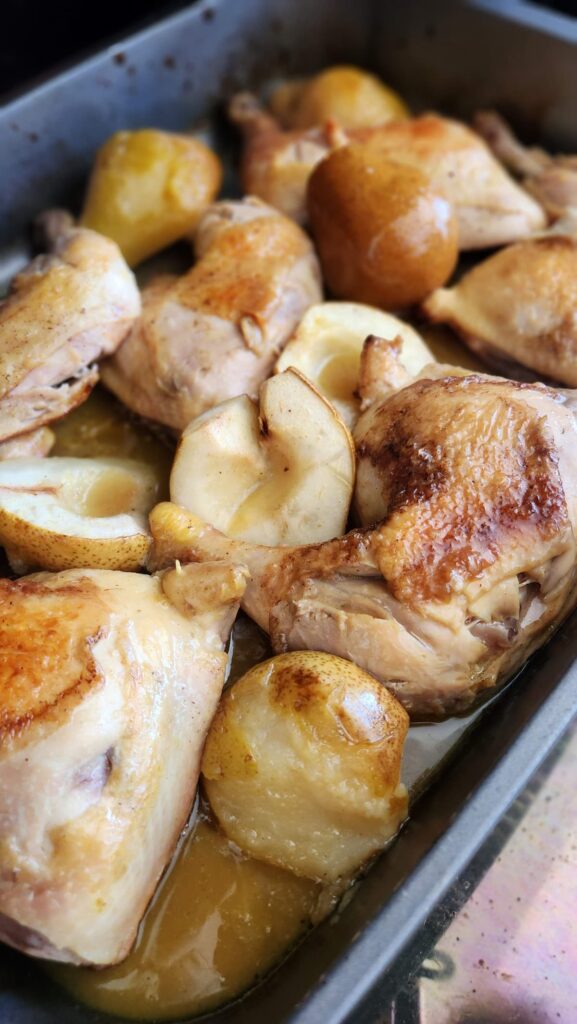 chicken and pears with sauce in roasting pan ready to bake