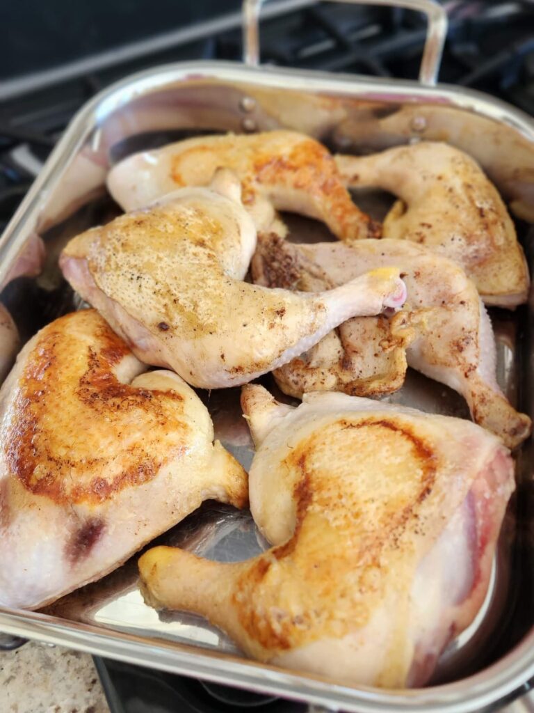 braised chicken legs placed in roasting pan